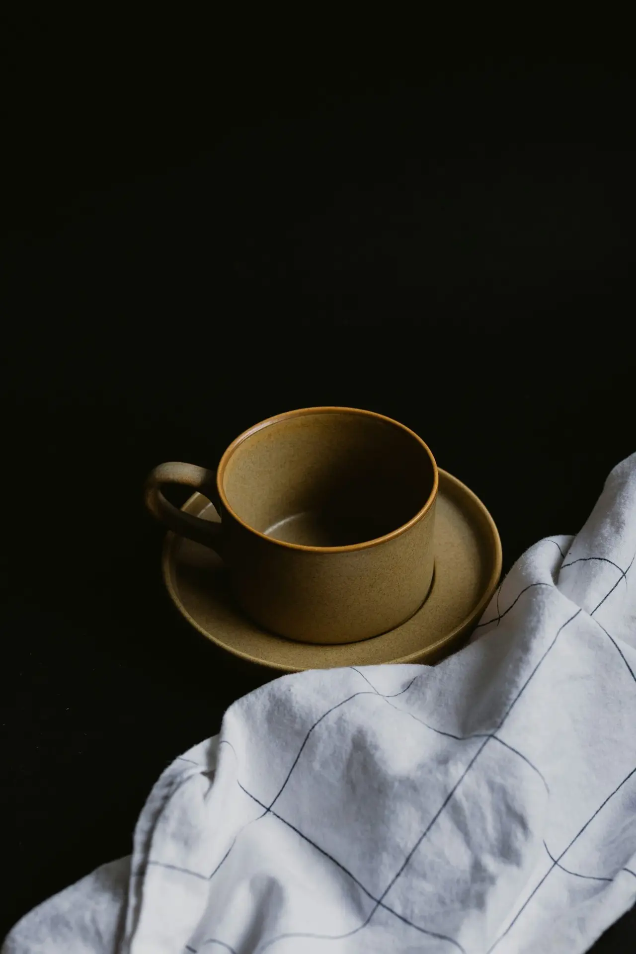 white ceramic mug on white textile